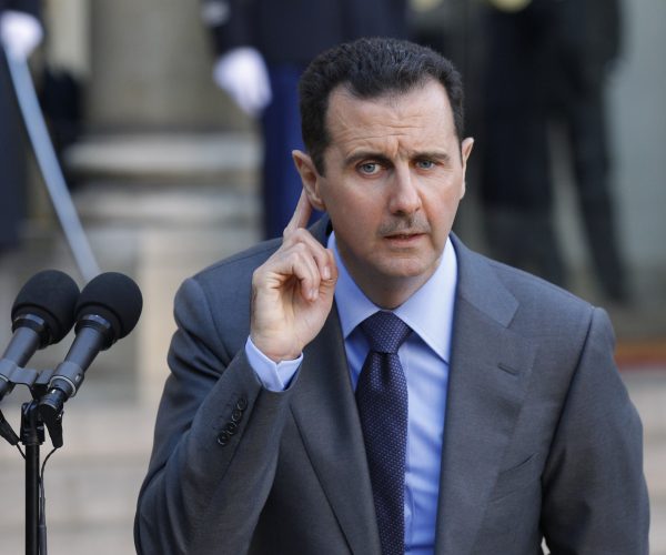 Syria's President Bashar al-Assad answers journalists after a meeting at the Elysee Palace in Paris, December 9, 2010. REUTERS/Benoit Tessier (FRANCE - Tags: POLITICS)